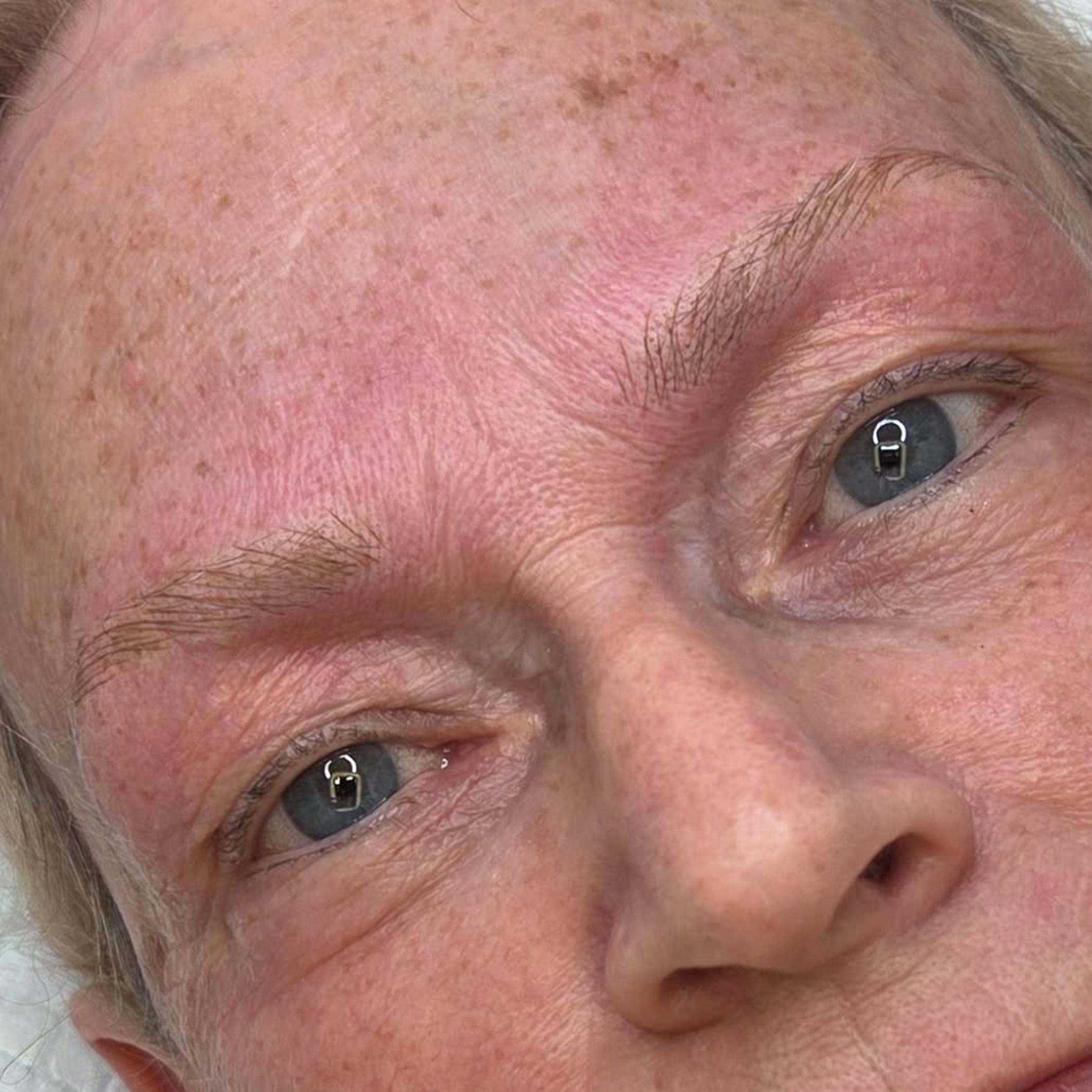 cosmetic tattoo technician applying brows